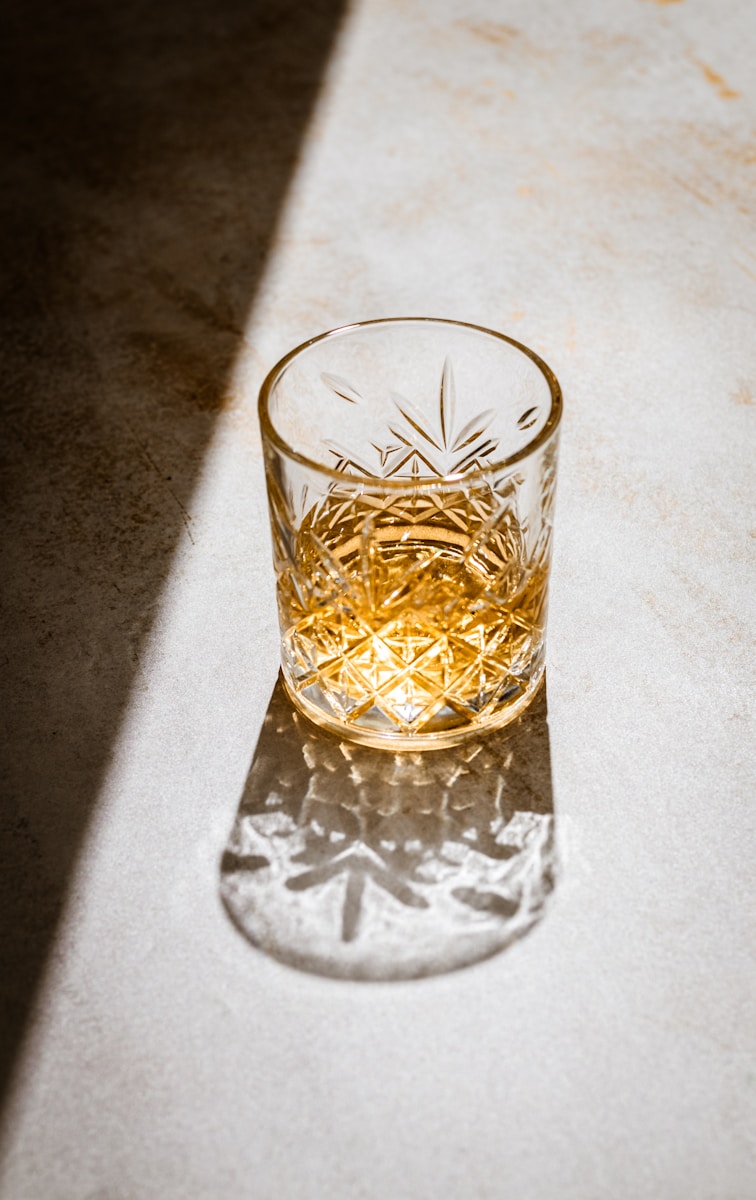 a glass of whiskey sitting on top of a counter